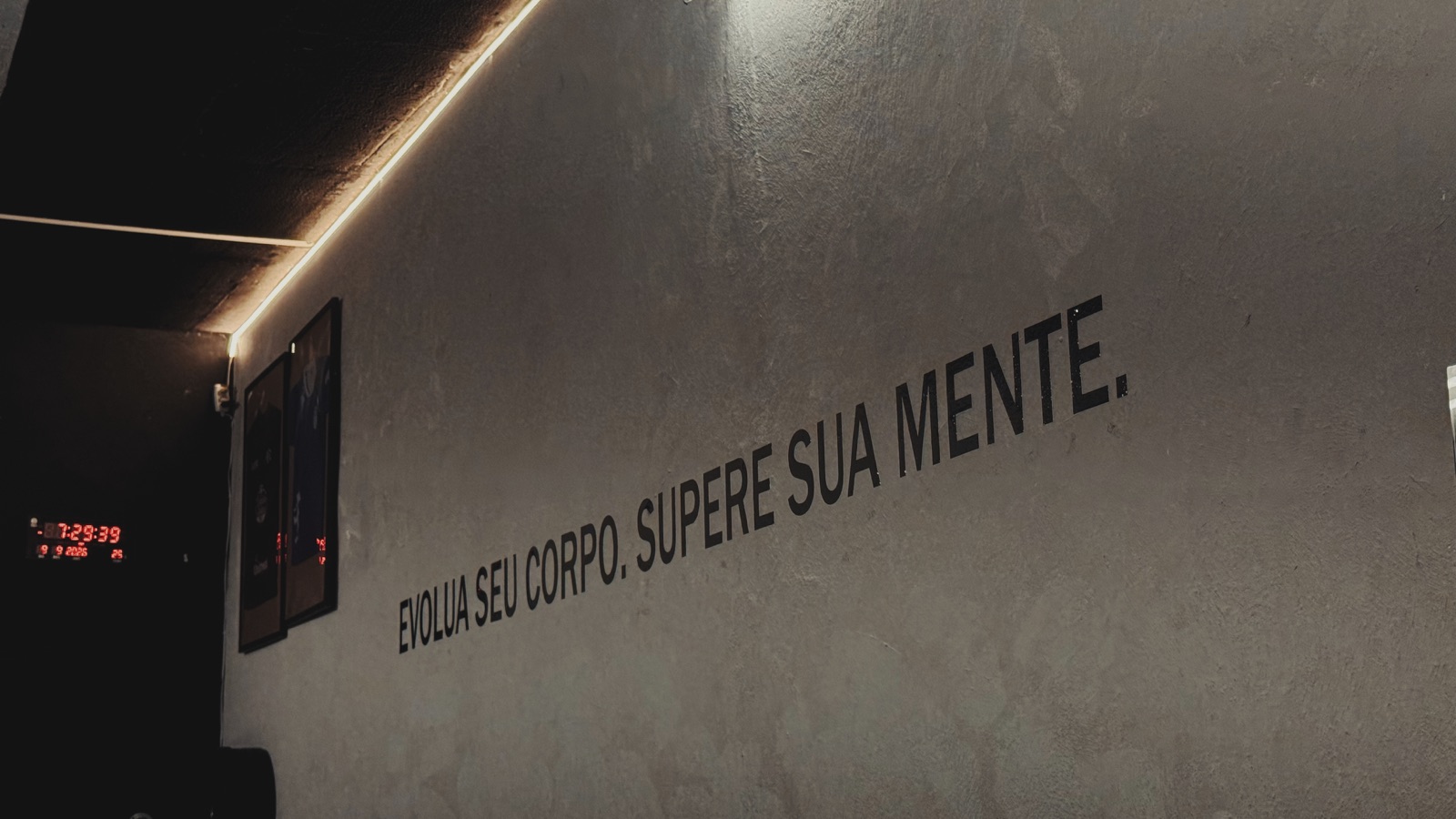 Parede do studio com o lema Evolua seu corpo, supere sua mente